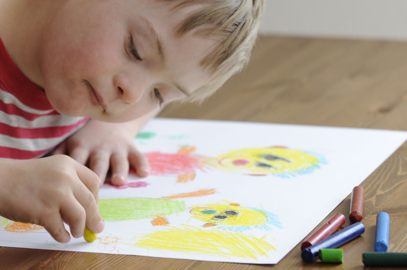 Boy with Down's Syndrome coloring a picture